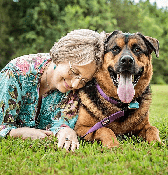 Cindy Brody with a dog laying in the grass